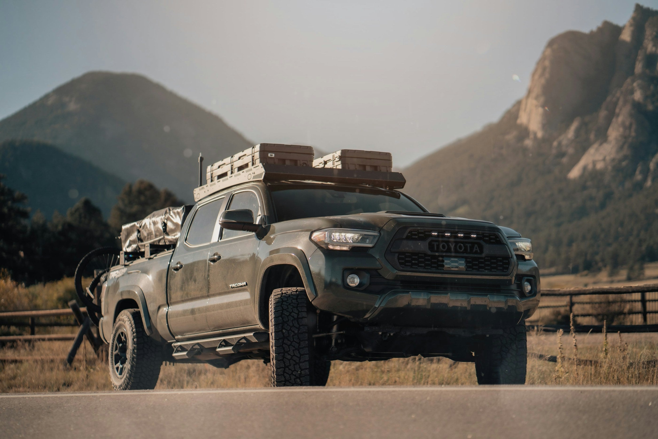 Overland-built Toyota Tacoma with loaded roof rack in the mountains