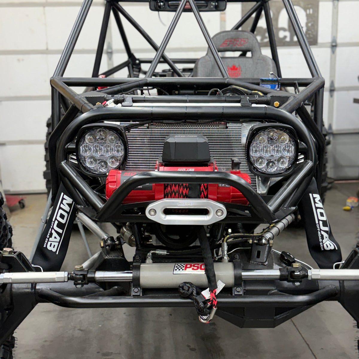 MOJAB OFFROAD MOJAB MO10.0 R-Series 10,000 lb off-road winch with rugged metal drum and control cable in a natural outdoor setting