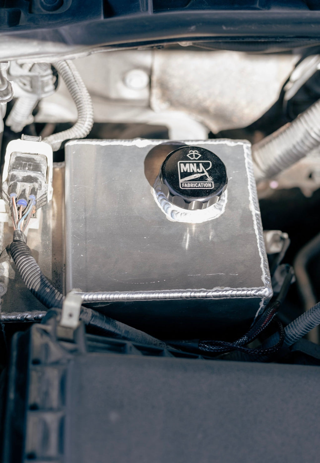 MNJ Fabrication aluminum washer fluid reservoir kit installed in a 5th Gen Toyota 4Runner (2010–2023), showing the relocated reservoir setup.