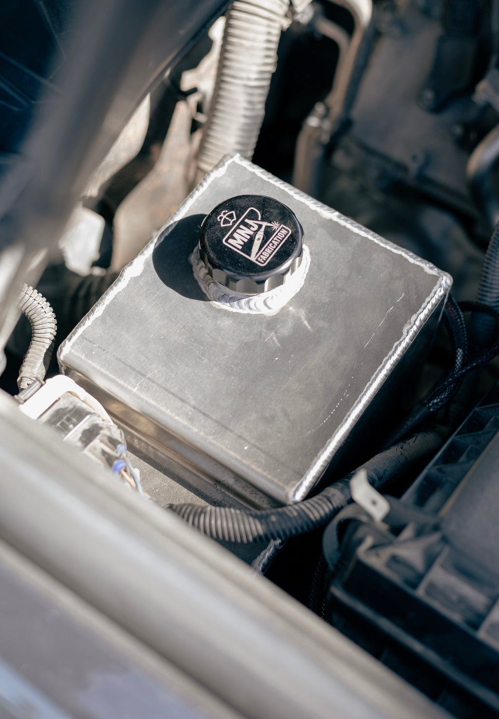 Aluminum washer fluid reservoir kit installed in a 5th Gen Toyota 4Runner, showcasing durable construction and custom fit by MNJ Fabrication.