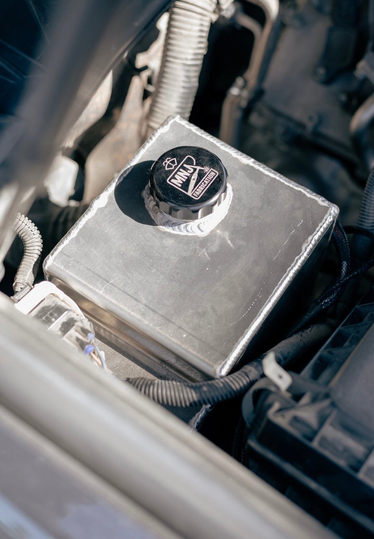 Aluminum washer fluid reservoir kit installed in a 5th Gen Toyota 4Runner, showcasing durable construction and custom fit by MNJ Fabrication.