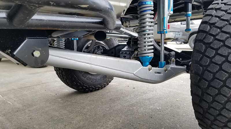 Riley Mountain Motorsports URC trailing arms pair installed on a vehicle, showing the durable steel construction and mounting points.