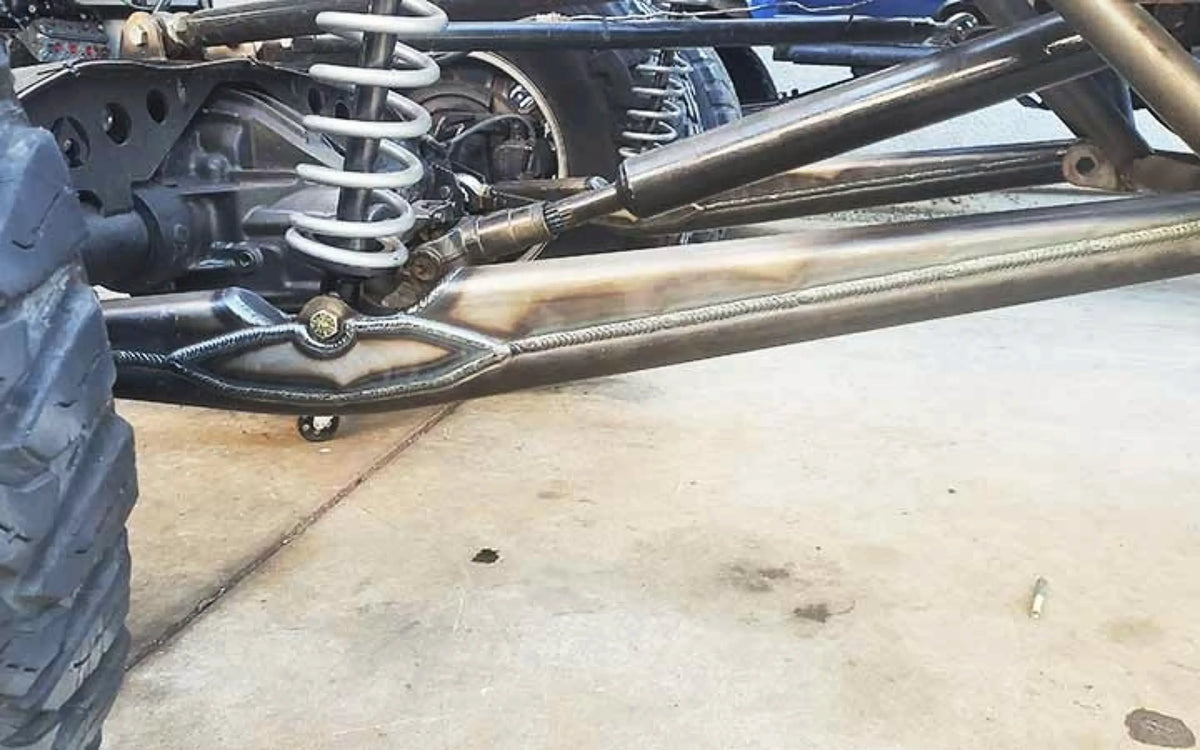 Pair of 40-inch Riley Mountain Motorsports URC single shock trailing arms, durable metal suspension components with mounting points.