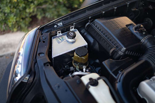 Aluminum washer fluid relocation reservoir kit for 4th gen Toyota 4Runner (2003–2009) by MNJ Fabrication, shown installed in engine bay.