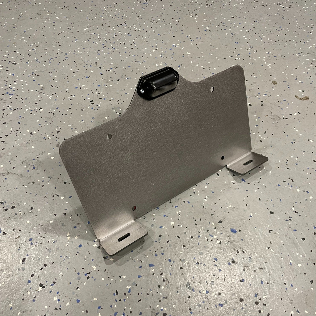 Heavy-duty steel bottom top mount license plate holder for trailers, RVs, and semi-trucks with integrated LED light by Elevate Metalcraft.