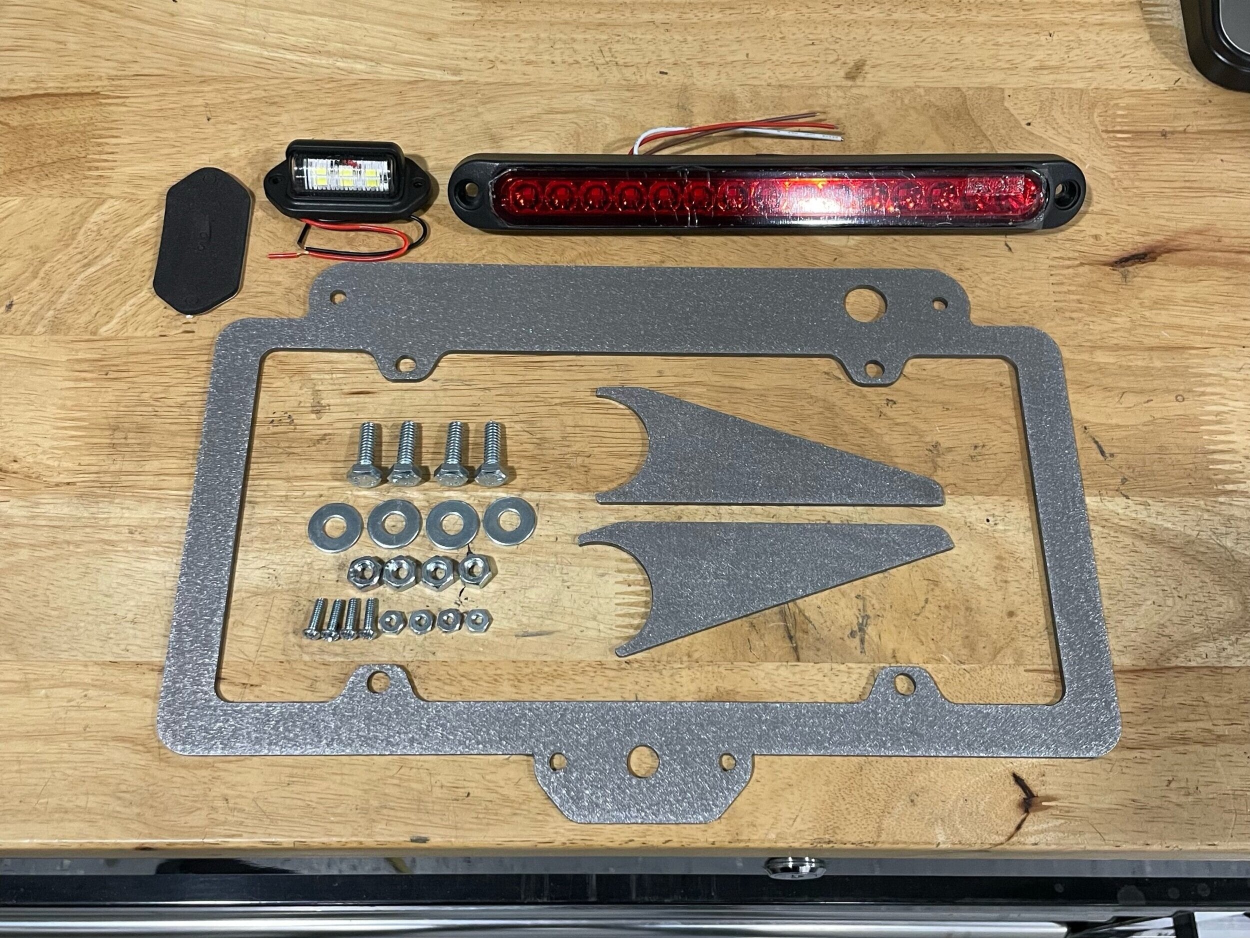 Elevate Metalcraft license plate relocation frame with 3rd brake light weld-on for tubing 1.5 and 1.75 inches, mounted on vehicle.