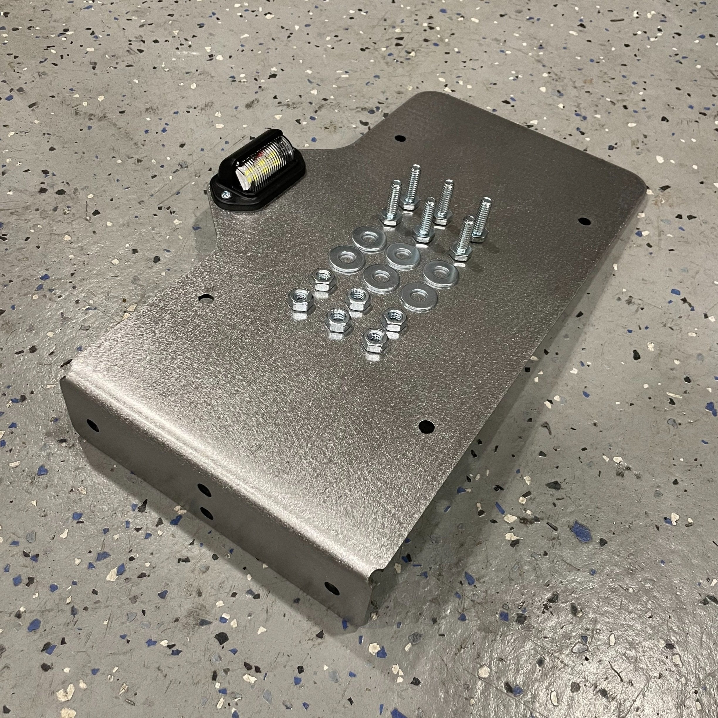 Heavy-duty steel side mount license plate holder for trailers, RVs, and semi-campers with LED light, by Elevate Metalcraft.