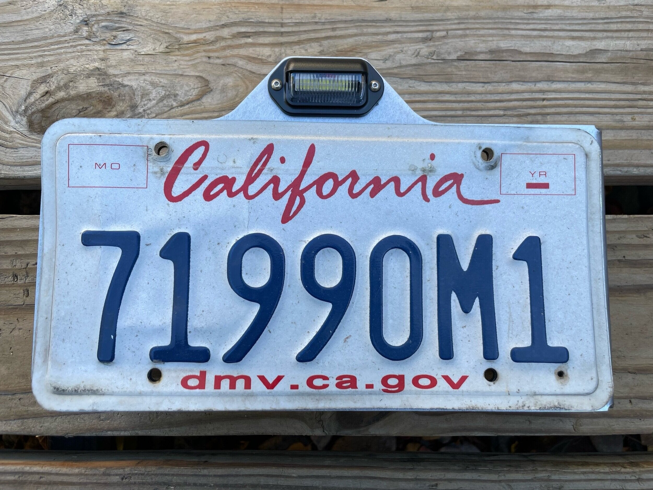 Heavy-duty steel side mount license plate holder for trailer, RV, or semi with LED light from Elevate Metalcraft, right side view.