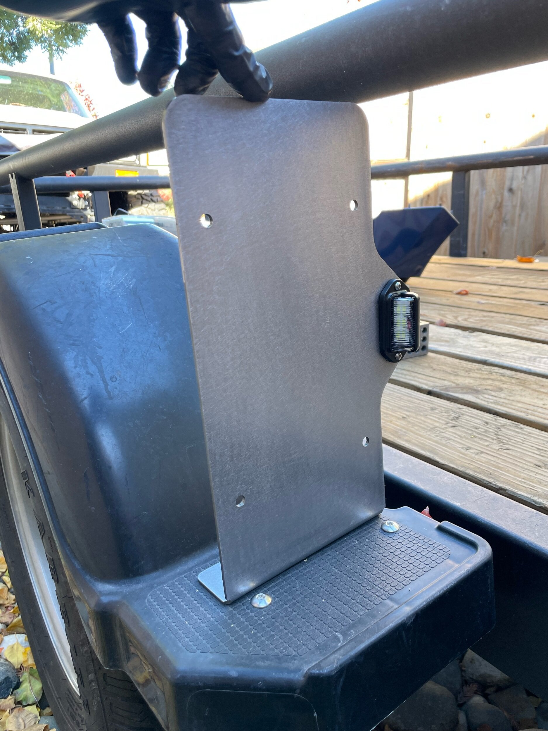 Heavy-duty steel side mount license plate holder for trailers, RVs, and semi-campers with integrated LED light on right or left side.