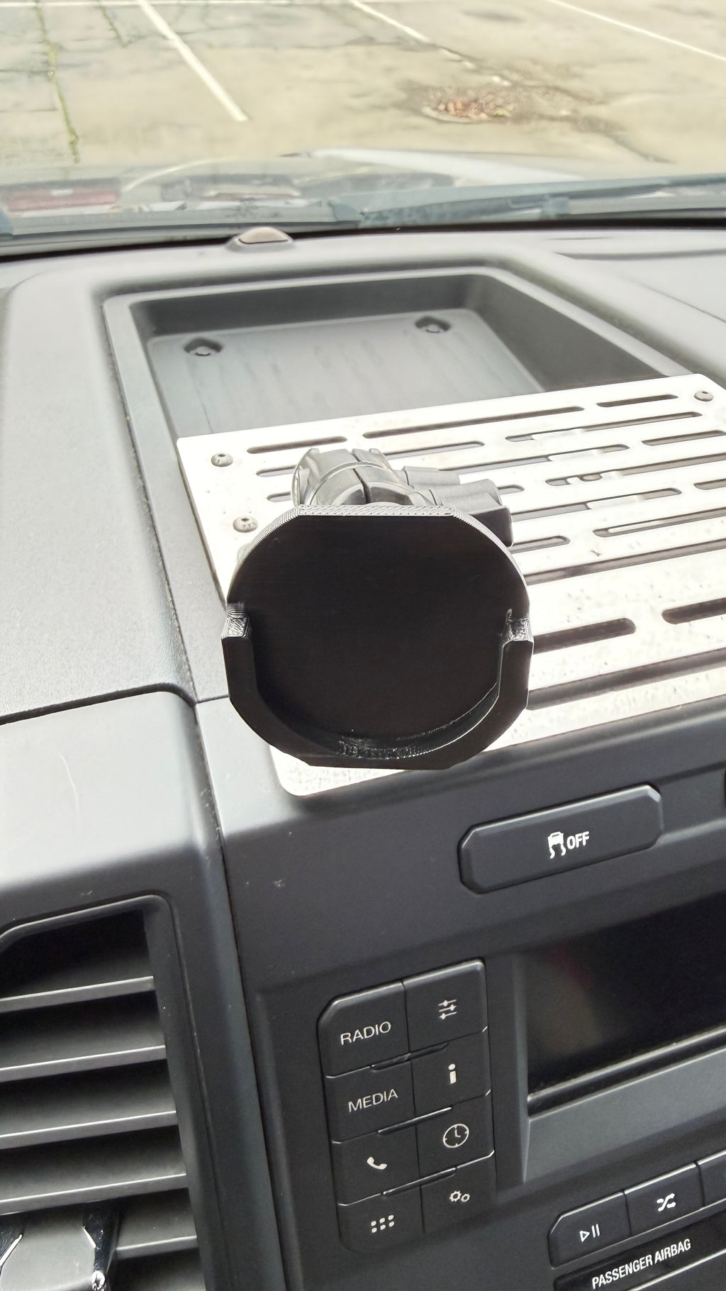 Black Elevate Metalcraft Quad Lock adapter attached to a PopSocket for secure phone mounting and compatibility.