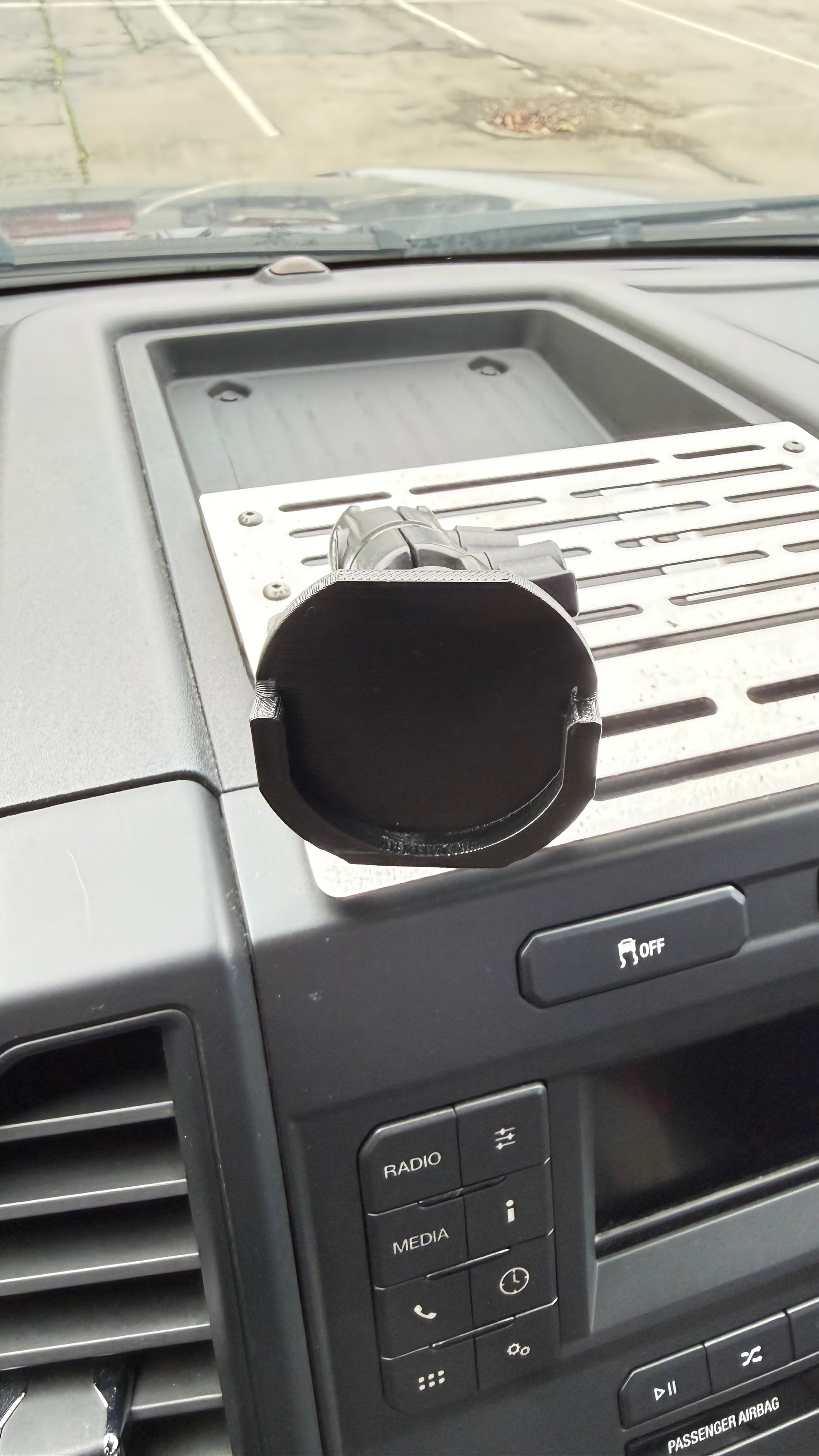 Black Elevate Metalcraft Quad Lock adapter attached to a PopSocket for secure phone mounting and compatibility.