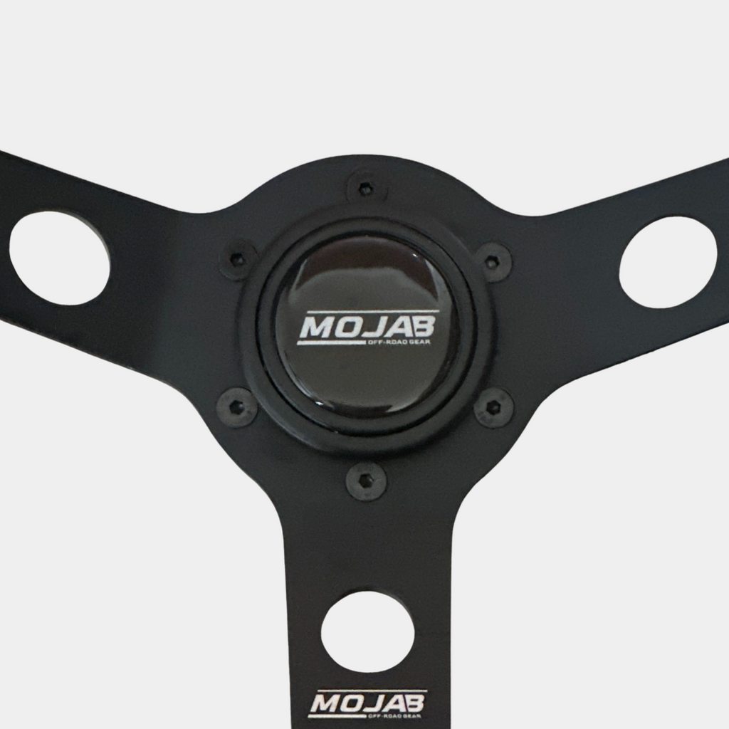13.5-inch MOJAB OFFROAD deep dish steering wheel in premium leather or suede, showcasing the textured grip and sleek design.