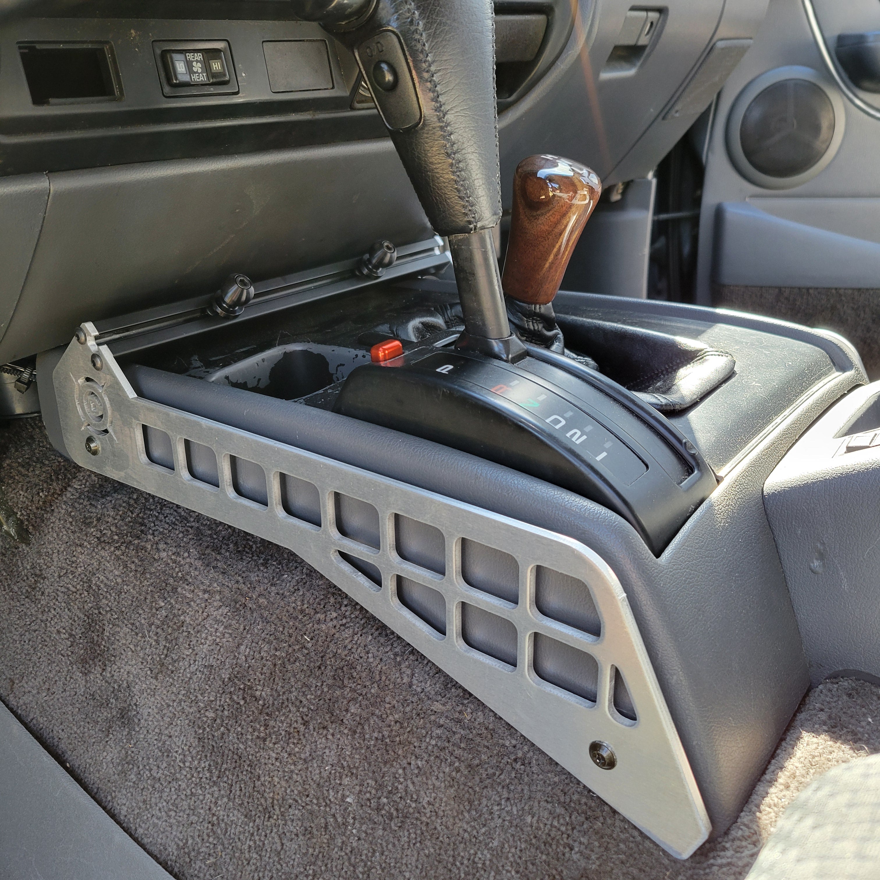 Overland Custom Design 80 Series Center Console Mount for Toyota Land Cruiser, durable black metal with mounting hardware visible