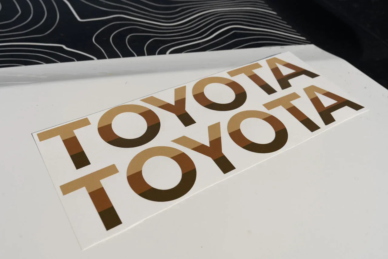 White Toyota Land Cruiser 2024+ front grille emblem overlays by StickerFab, designed for a sleek, customized look.